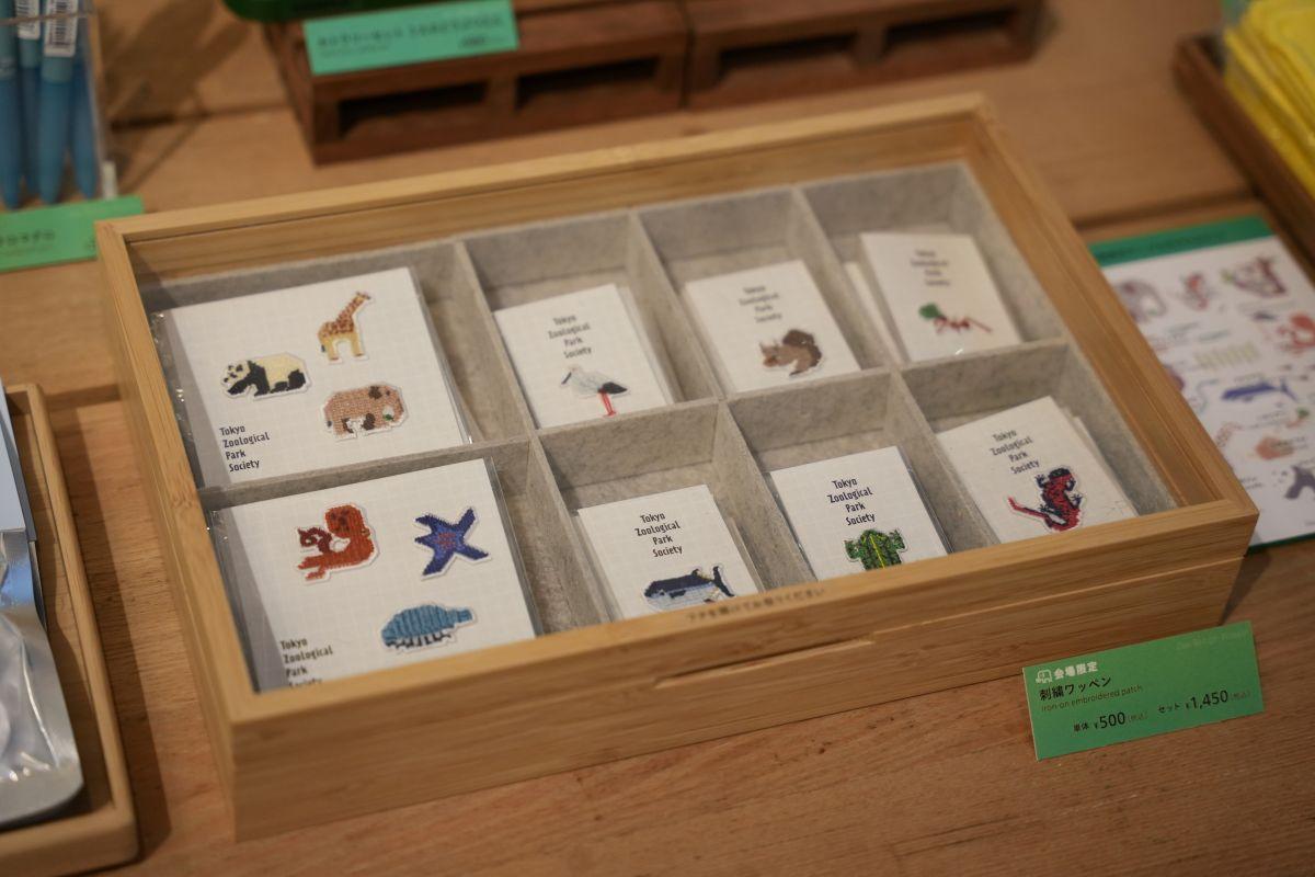 会場限定販売グッズ。刺繍ワッペン1個：500円（アジアゾウ、コウノトリ、二ホンリス、クロマグロ、トウキョウダルマガエル、アカハライモリ、ハキリアリ計6種）、3個セット：1，450円 （①アジアゾウ、ジャイアントパンダ、キリン ②イトマキヒトデ、マダコ、ダイオウグソクムシ計2種）。