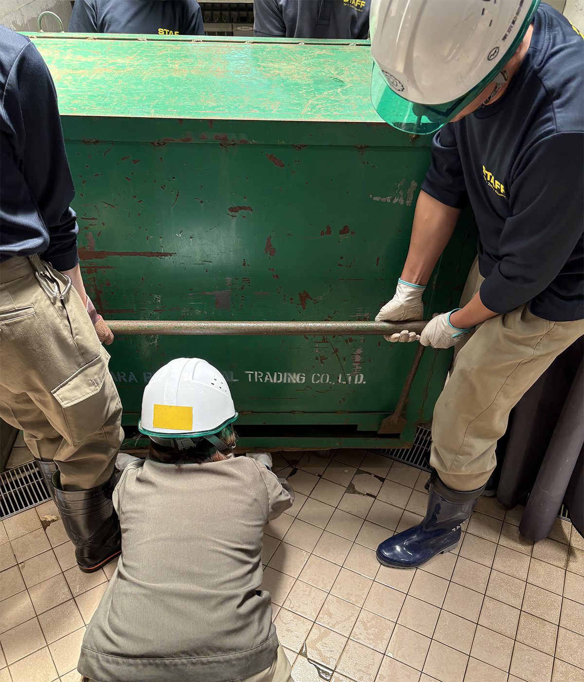 輸送箱運搬。箱を持ち上げ、運びやすいように下に台車を差し込んでいる